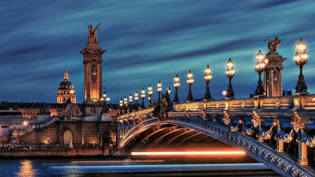 Pont Alexandre III illuminé la nuit à Paris, avec vue sur les monuments emblématiques