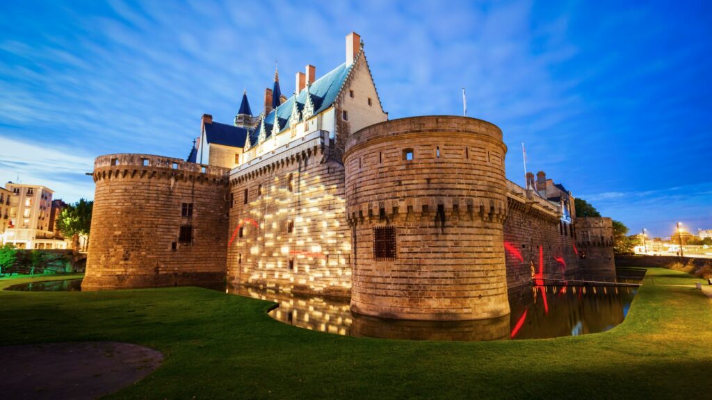 Château des Ducs de Bretagne illuminé à la tombée de la nuit à Nantes