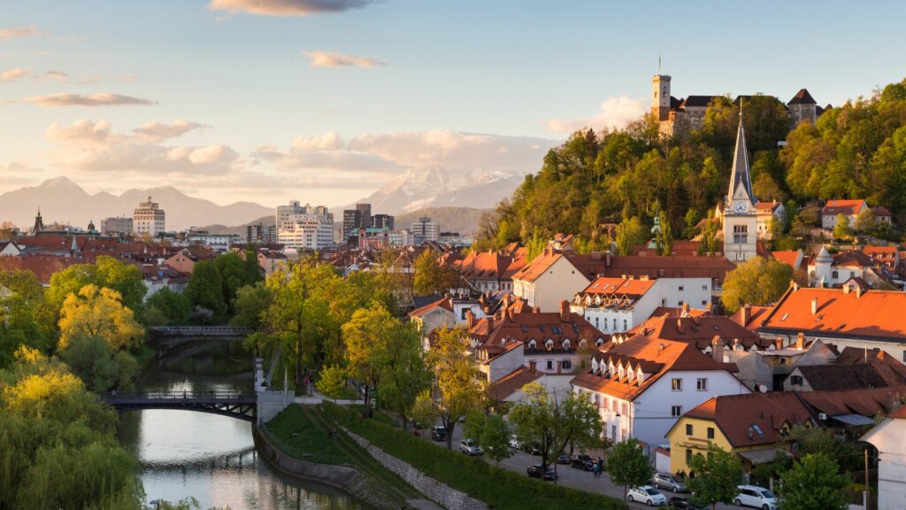 Vue panoramique de Ljubljana avec le château et les toits rouges au coucher du soleil.