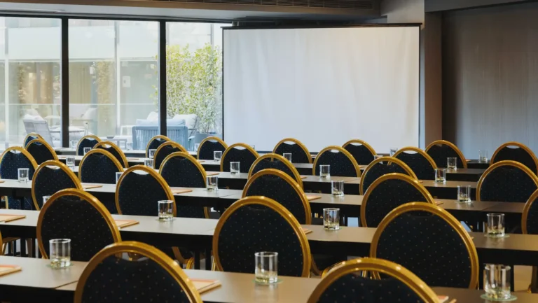 Salle de conférence du Timbre Heroísmo Porto en configuration école avec écran de projection et vue sur terrasse – séminaire entreprise