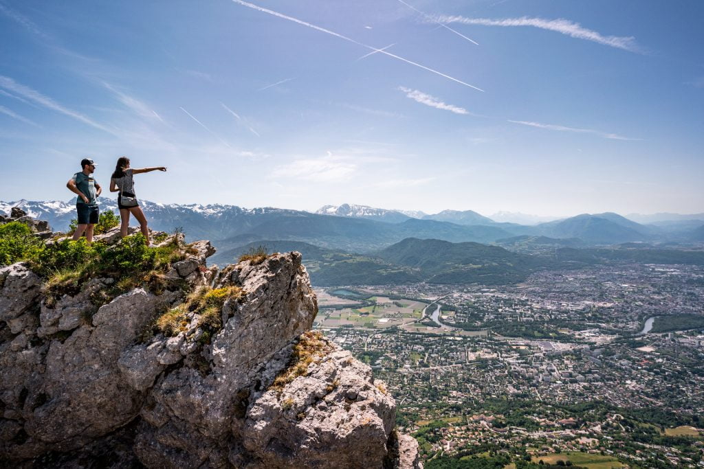 Deux personnes au sommet d'un massif alpin avec vue plongeante sur Grenoble – activité team building séminaire entreprise Grenoble