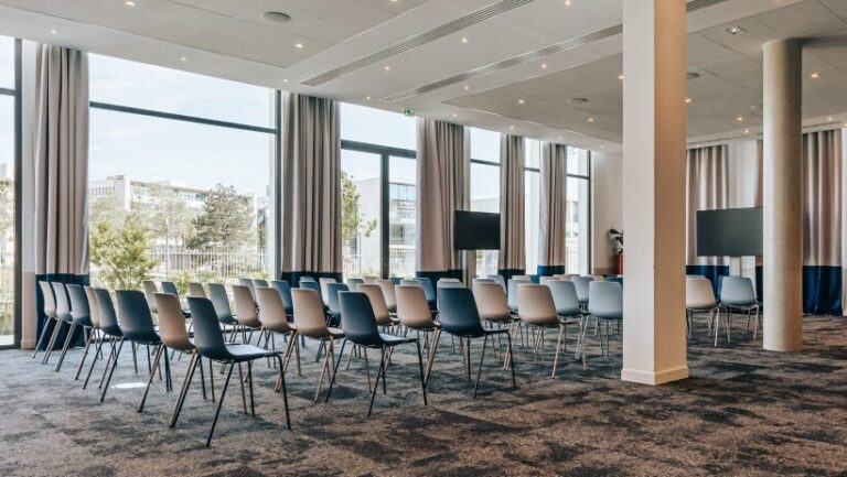 Salle de séminaire en configuration théâtre avec écrans et lumière naturelle – The Ruck Hotel – séminaire entreprise